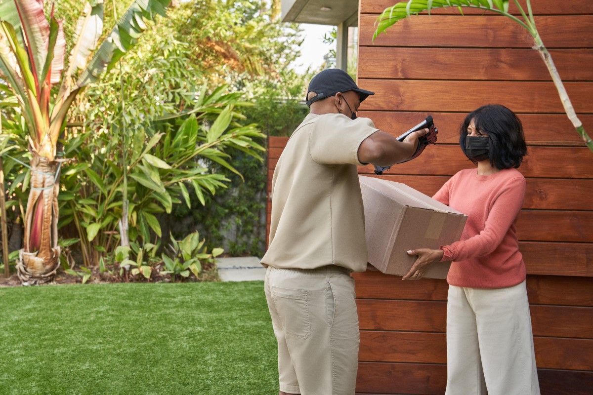 Delivery person hands package to customer