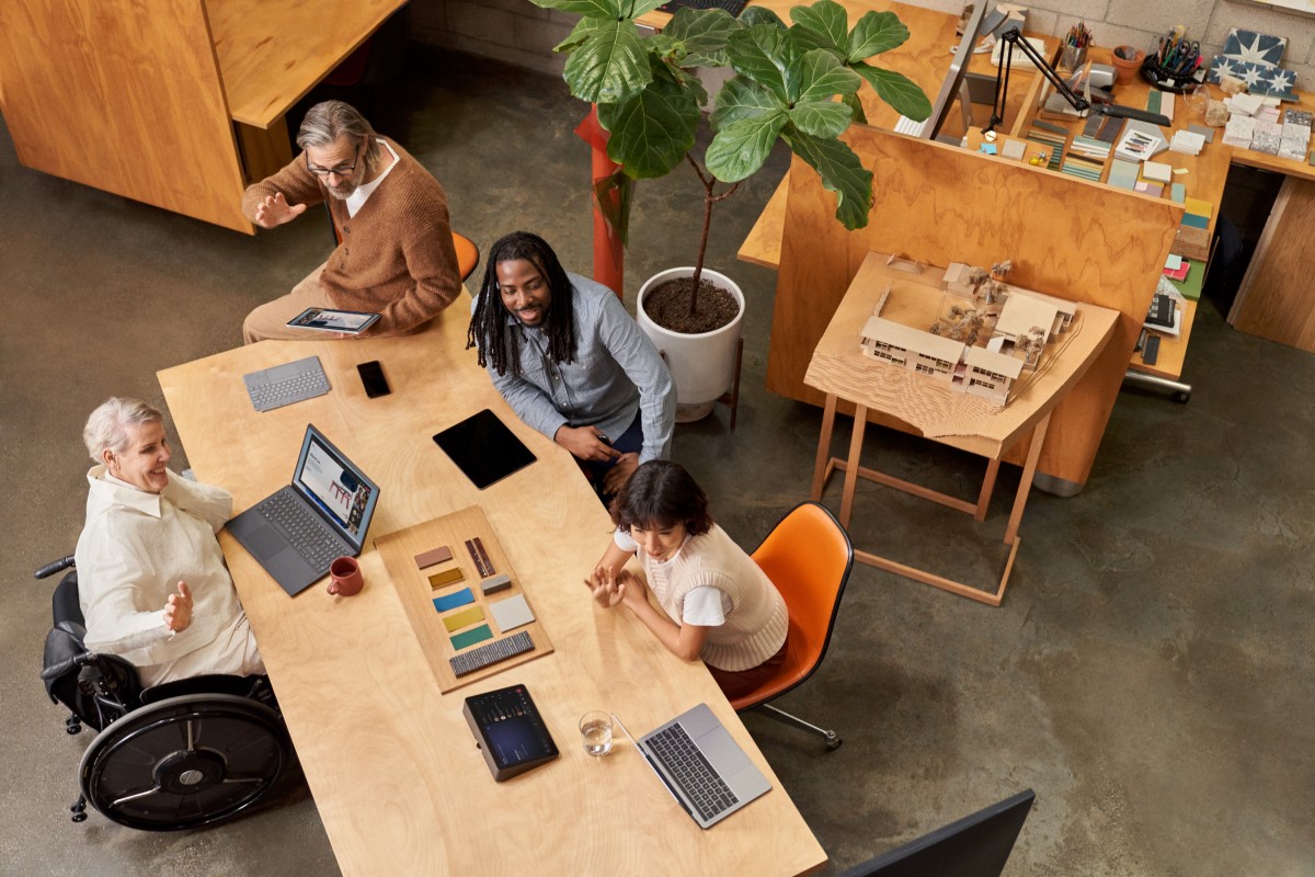 People in the conference room joining on a laptop via Companion Mode while a remote participant presents during a Microsoft Teams Room (M T R) meeting​