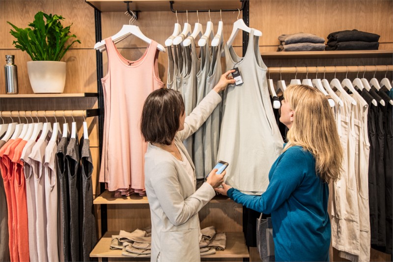 Store employee helping customer purchase clothing