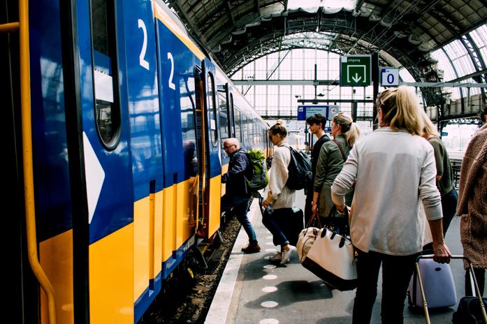 An image of a train station and people boarding a train