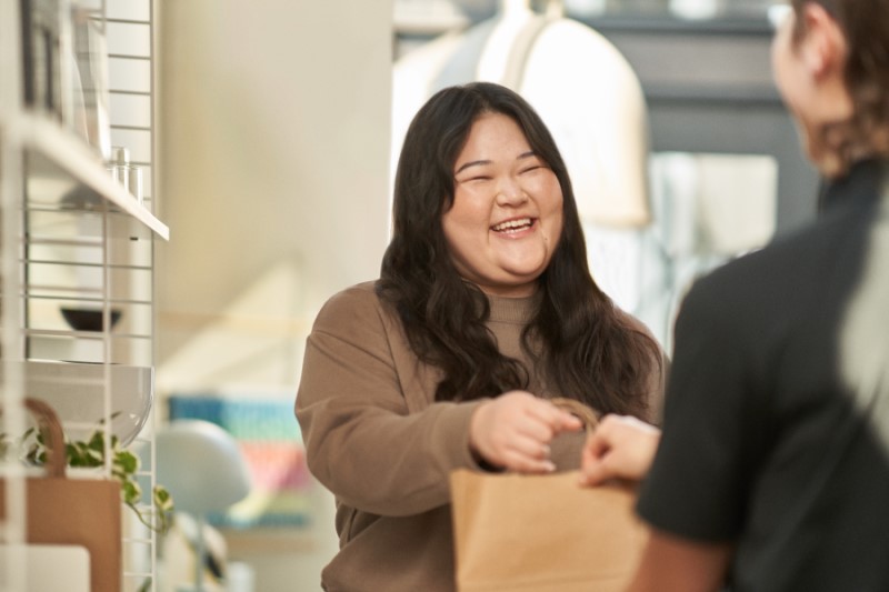 Retail customer picking up order in-store and checking out with customer service