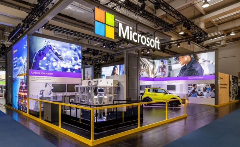 Side view of the Microsoft booth at Hannover Messe fair at Hannover Germany, April 17-22, 2023. Industrial equipment, robot and an electric vehicle are visible from this side of the booth