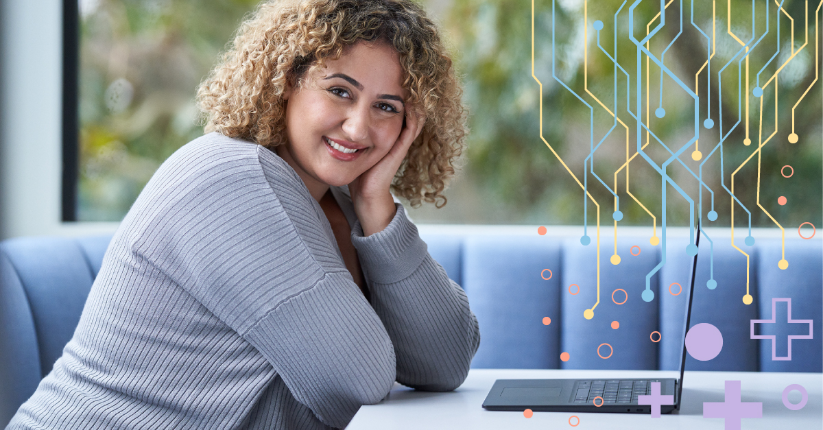 A woman sitting at a table with a computer open in front of her
