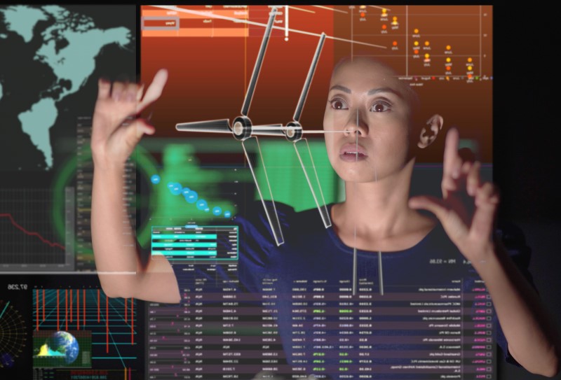 Asian woman working with a virtual touchscreen and expanding an image of a wind turbine in front of her