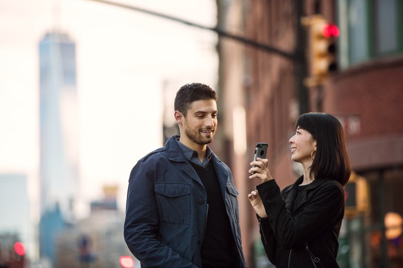 Female with phone with male on urban street
