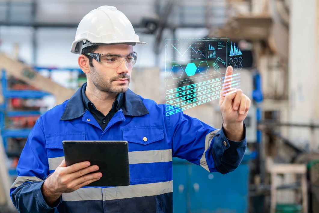 A portrait of a confident engineer touch the button at the screen and use digital tablet in a heavy industrial factory, concepts engineer working in the factory