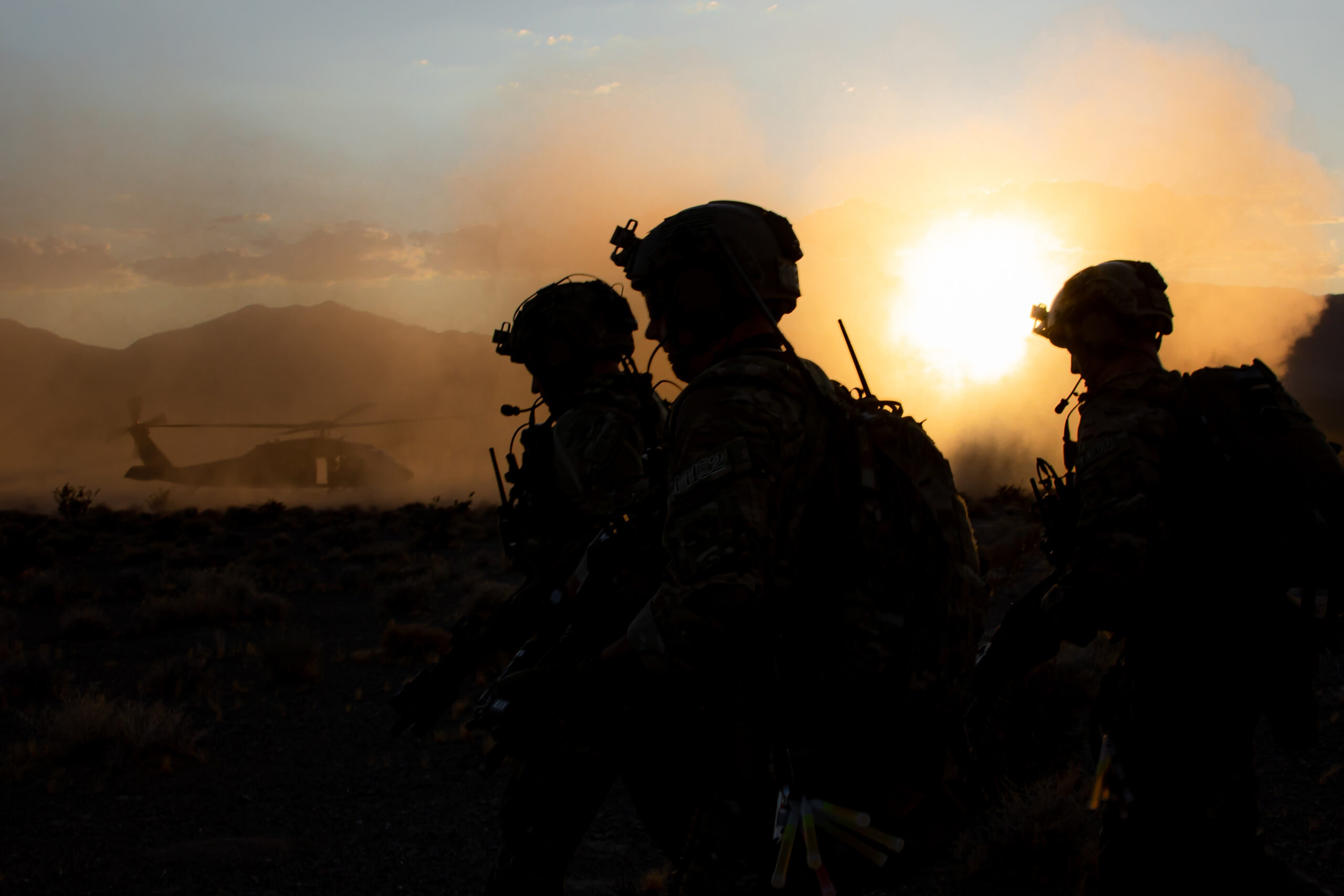 Soldiers in a field in front of a helicopter