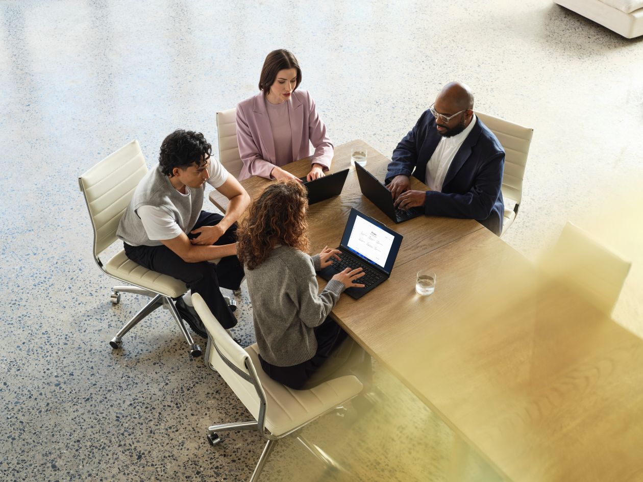 A Lenovo device being used by a mixed-gender team in an office space