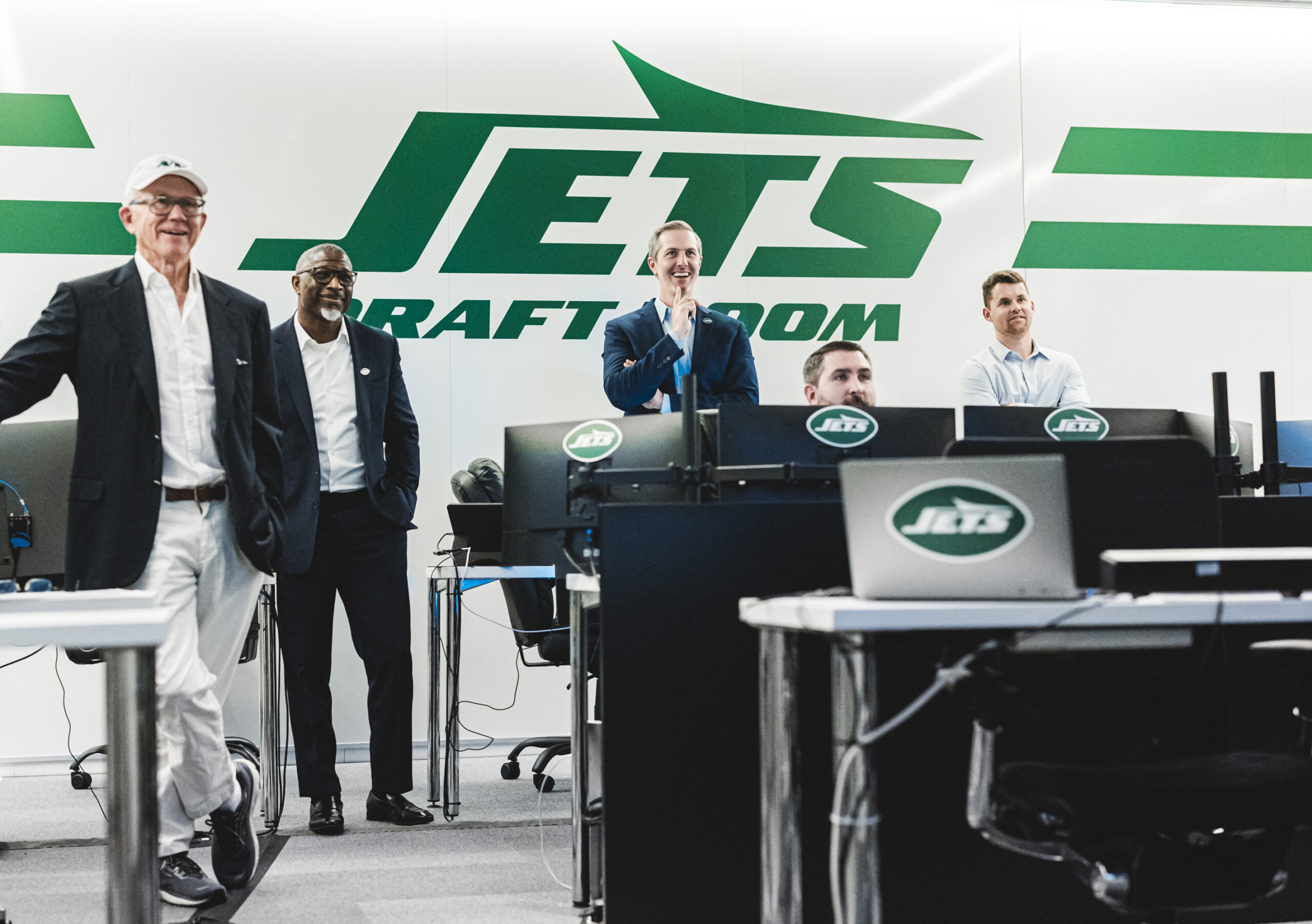 New York Jets staff smiling in their draft room