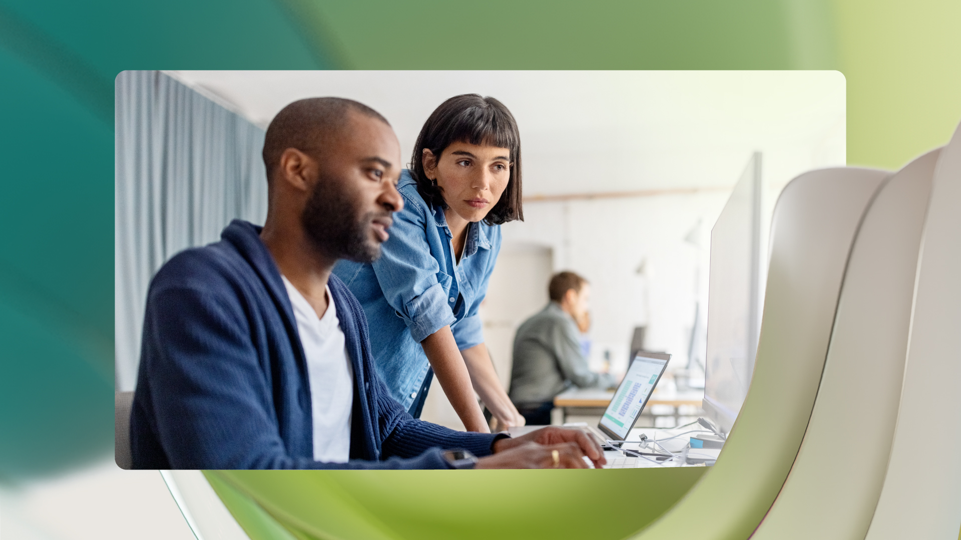 Two coworkers looking at data on a computer
