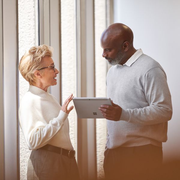 Two business professionals looking at the screen of a tablet and collaborating.