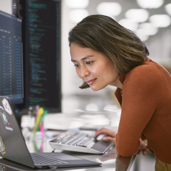 A person working on a computer in an open office setting.