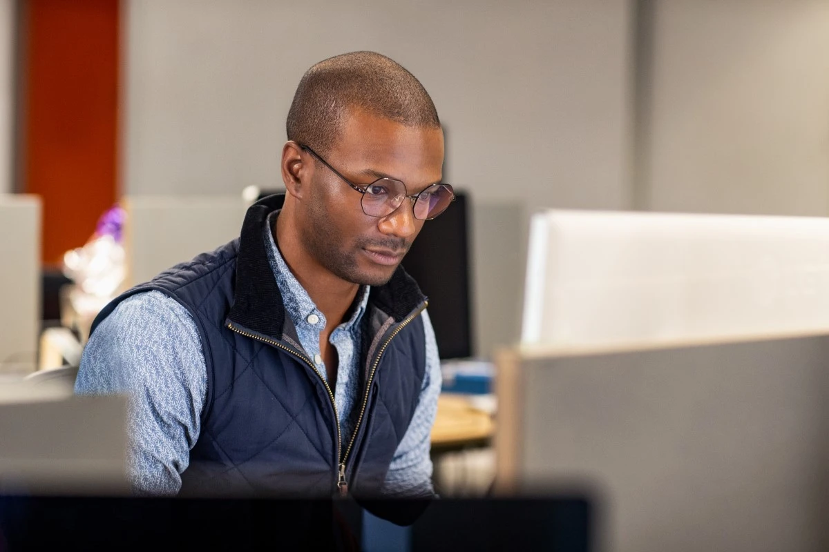 Real people, real offices. Black male developer at work in an Enterprise office workspace. Focused work. Code, develop, black developer, engineer, Visual Studio, Azure