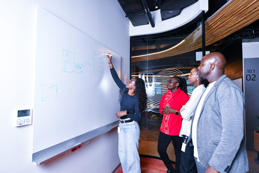 a group of people looking at a whiteboard