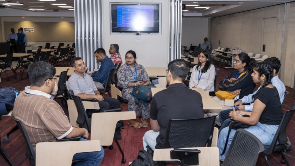 Photograph of a group of 8 people in a conference room having a breakout discussion.