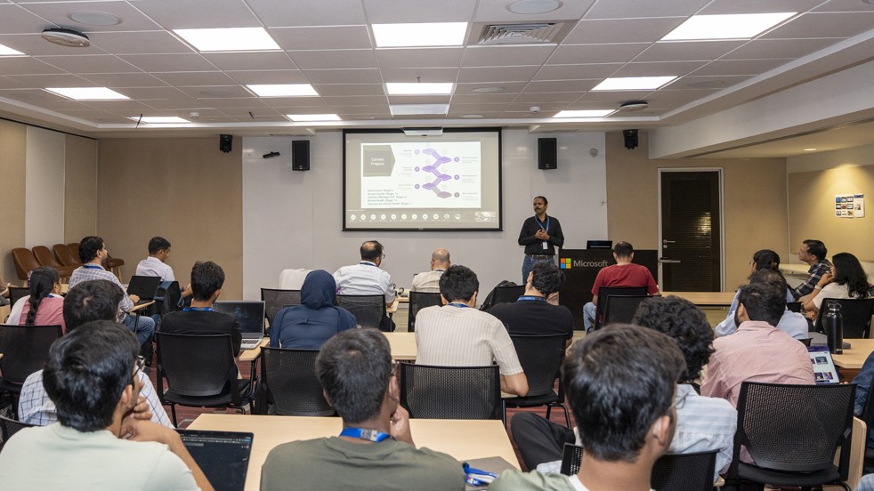 Photograph of a person giving a presentation to an audience of about 25 people.