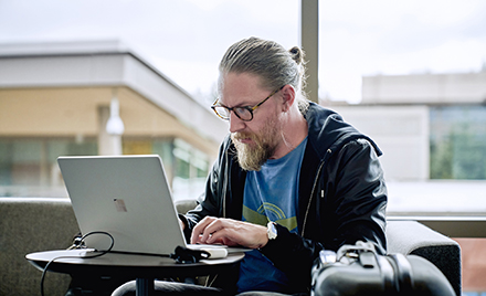 Image of a man working at a laptop