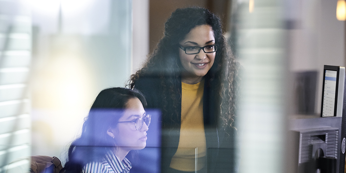 Two adult women working together at a computer