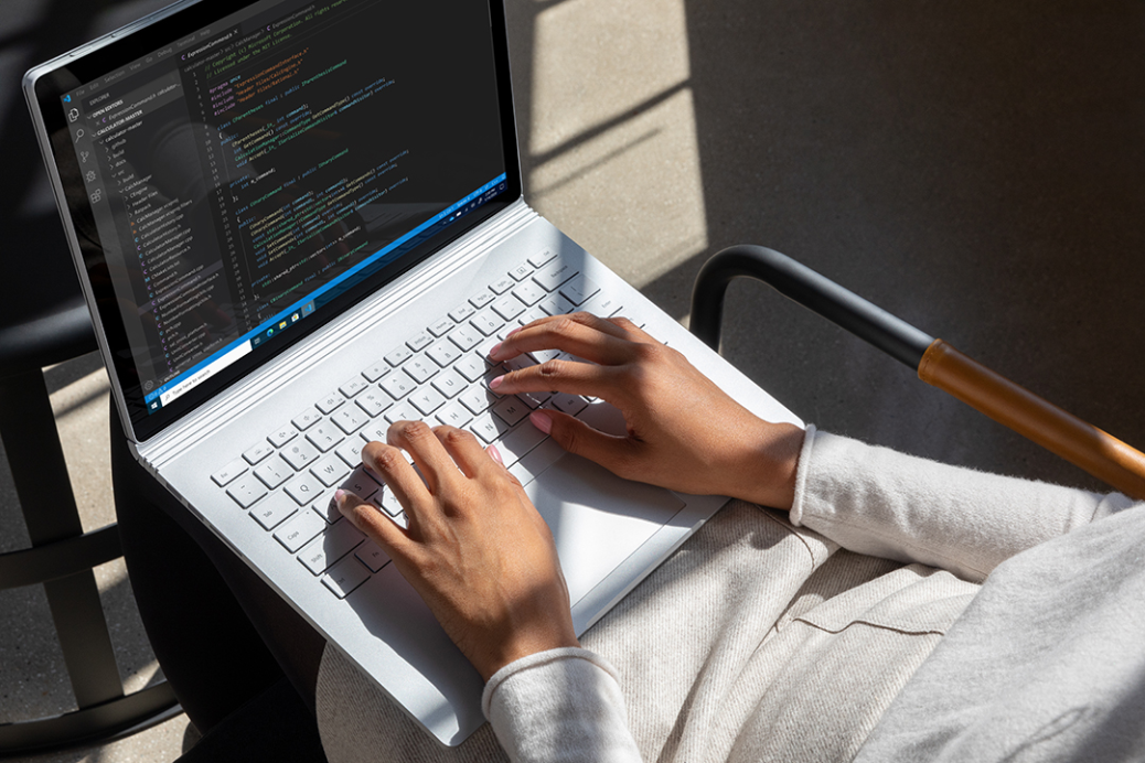 Commercial contextual lifestyle image of adult female working in Azure on Surface Book 3 inside