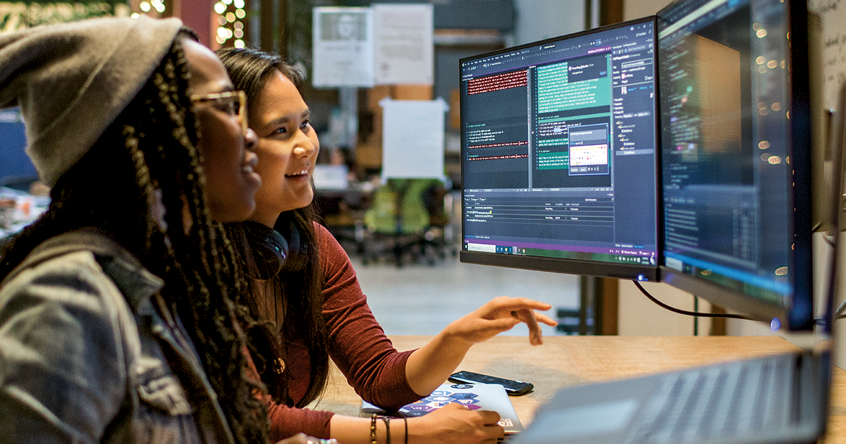 Two female developers working and collaborating in an enterprise office