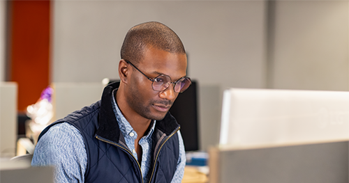 An image of a black male developer at work in an Enterprise office workspace