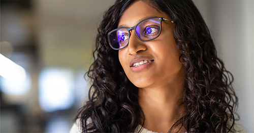 An image of a female developer smiling off camera
