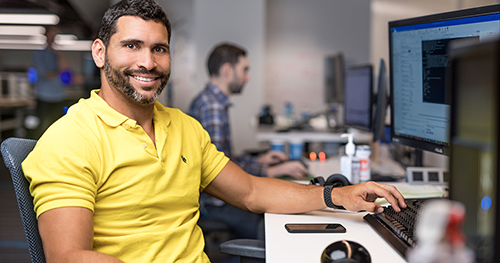 An image of a tech worker sitting at his desk