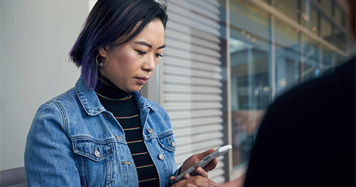 An image of a woman reading message on her phone