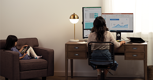An image of a mother and her daughter are working and learning remotely in their living room