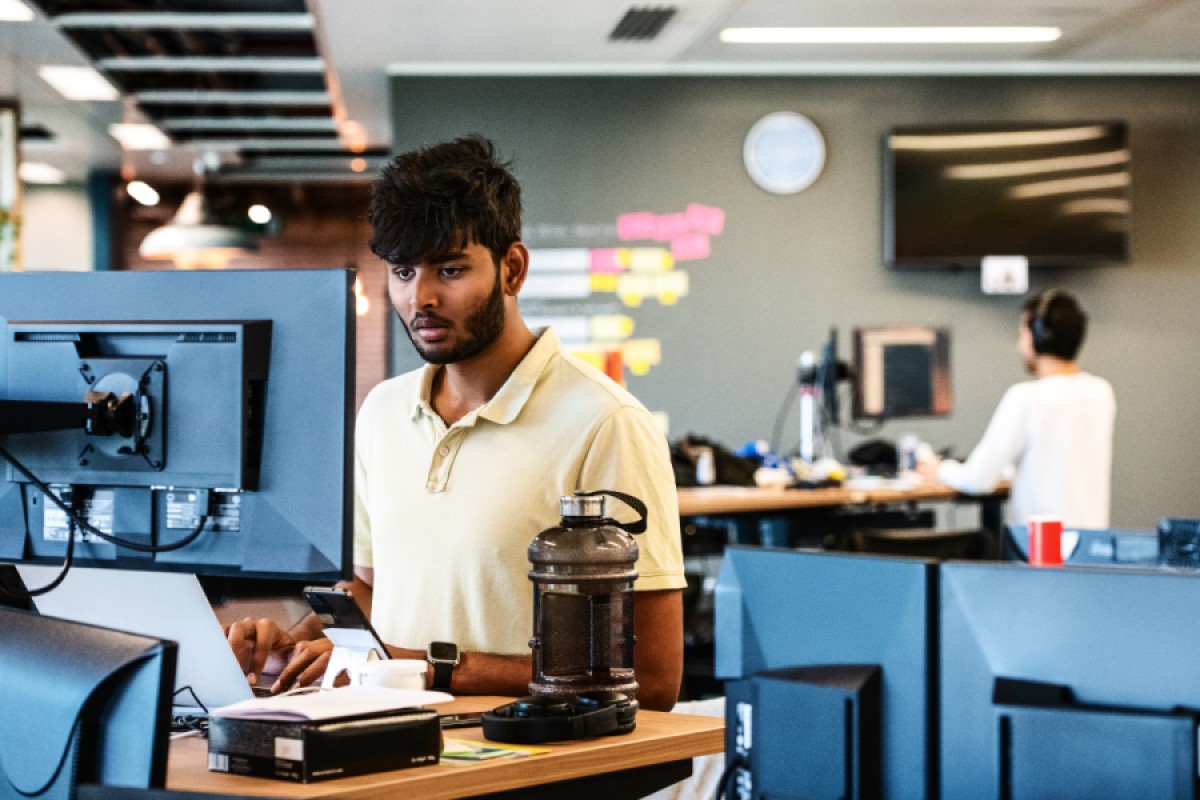 An employee in the tech industry works at a standing desk in UK office