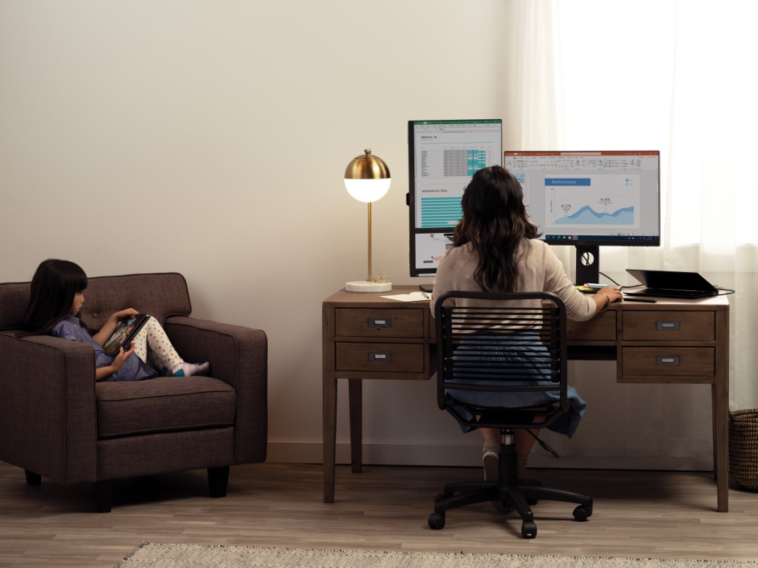 A mother and her daughter are working and learning remotely in their living room