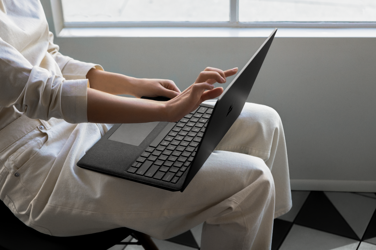 Contextual image of woman touching screen while working on Black Surface Laptop2