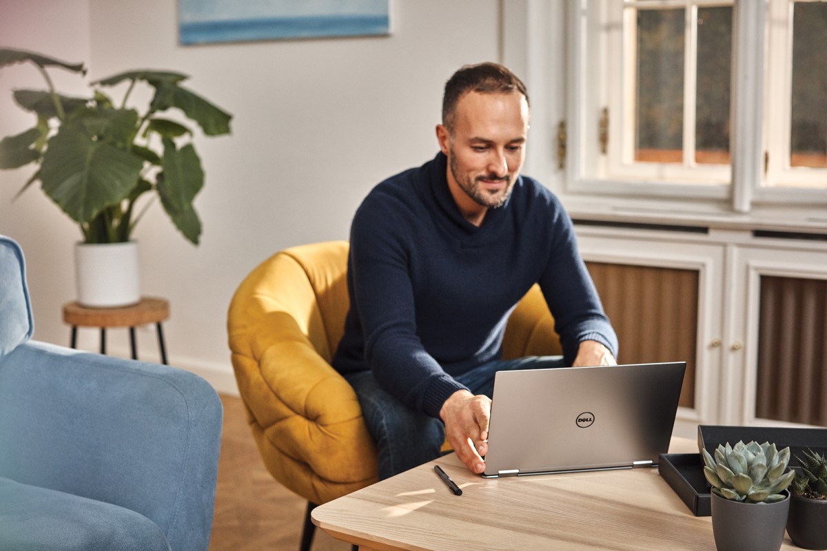 Adult male working from coffee table on Dell laptop