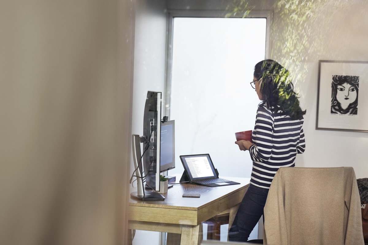 Female working remotely from home office on a Surfce Pro 6 device, standing at desk