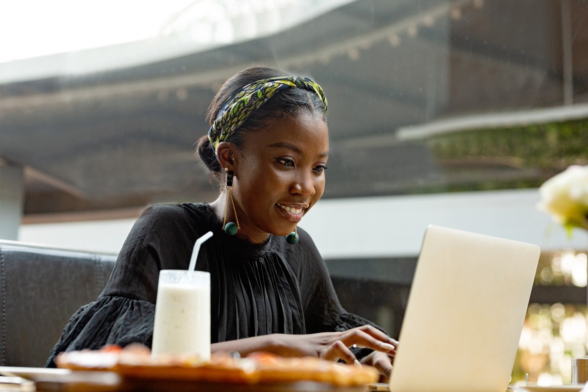 A young woman works remotely on her laptop