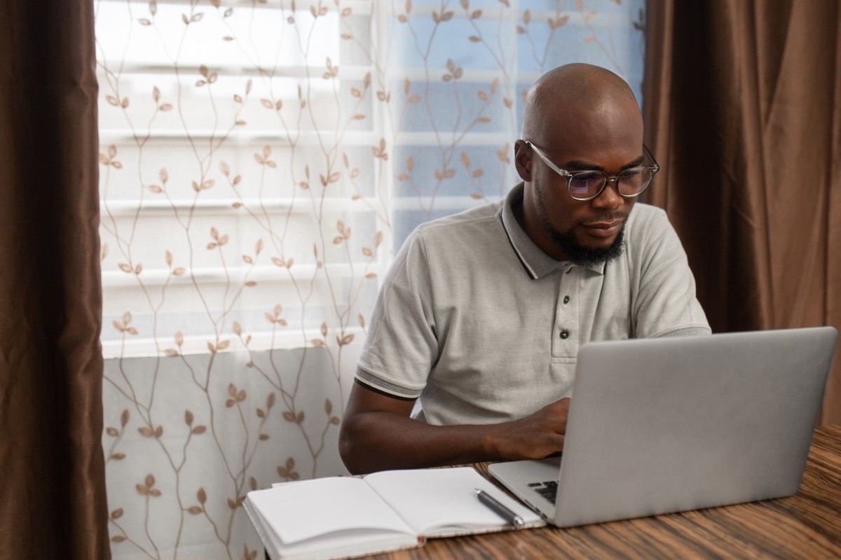 A young man works on his laptop from home