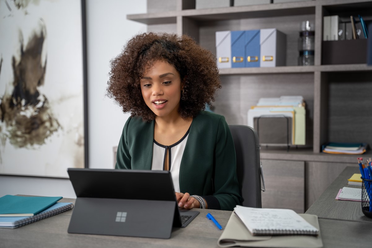 An interior design expert using Microsoft Teams on a Surface laptop to remotely assist an onsite retail store manager using Dynamics 365 Remote Assist on HoloLens 2 to design the layout of the store