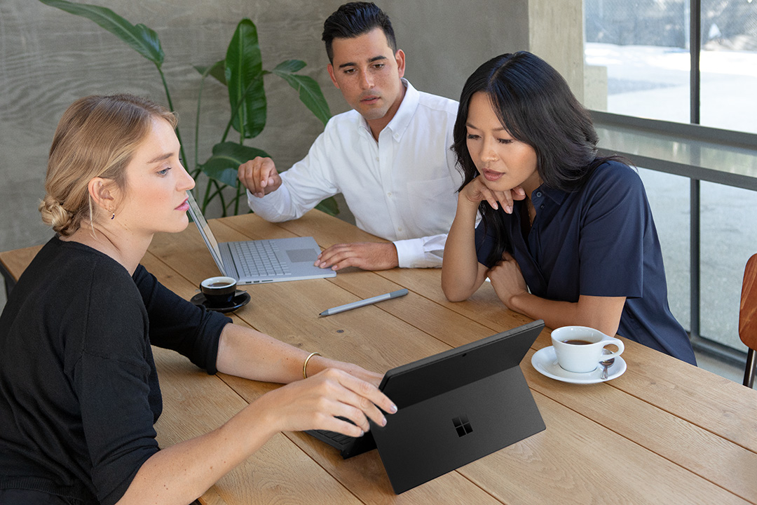 Small group of professionals working on laptop in office