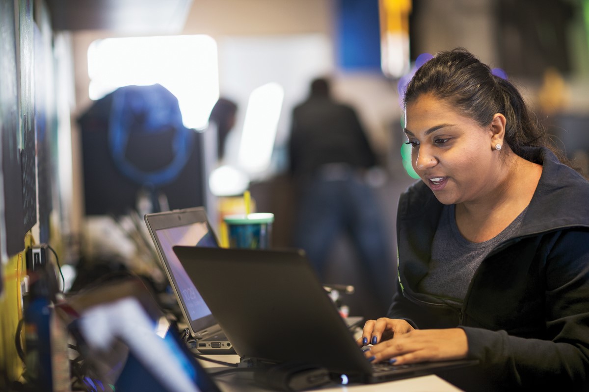 Adult woman working on multiple laptops