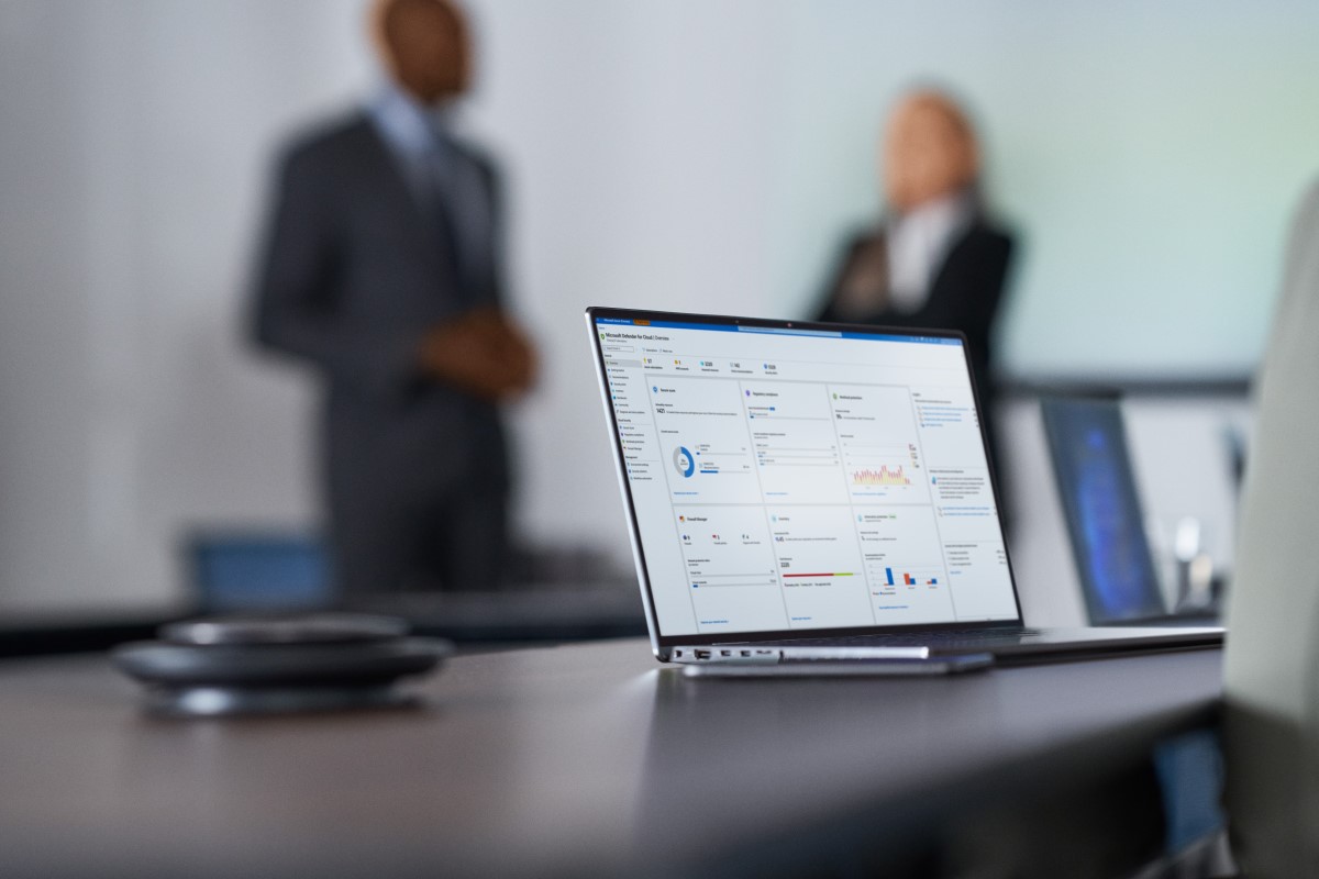Camera focused on laptop screen showing security dashboard while security decision makers present to the board of executives on security topics