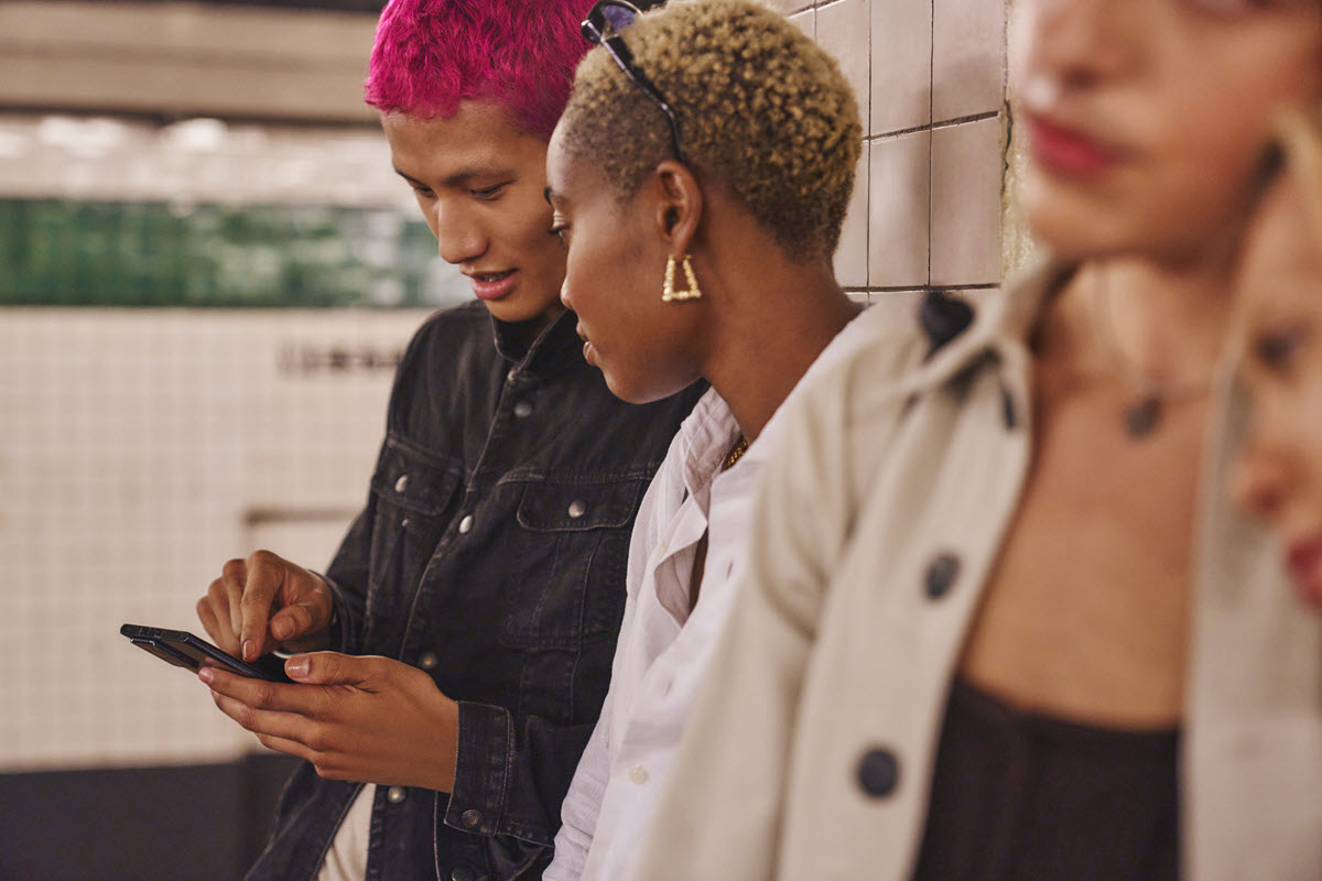 Two people in the subway looking at a mobile device