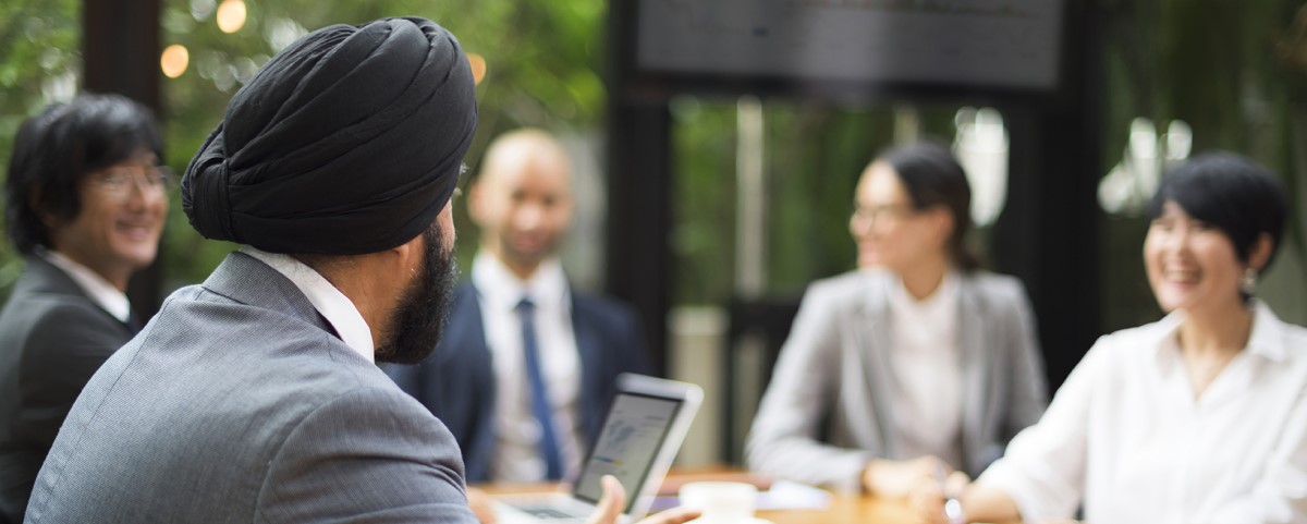 A group gathers around a table having a meeting in an office