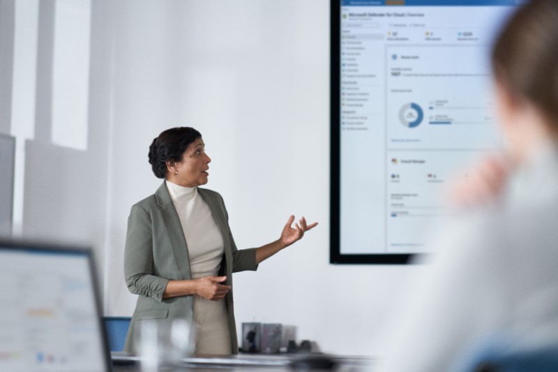 Chief information security officer presents to the board of executives on security topics in a conference room setting