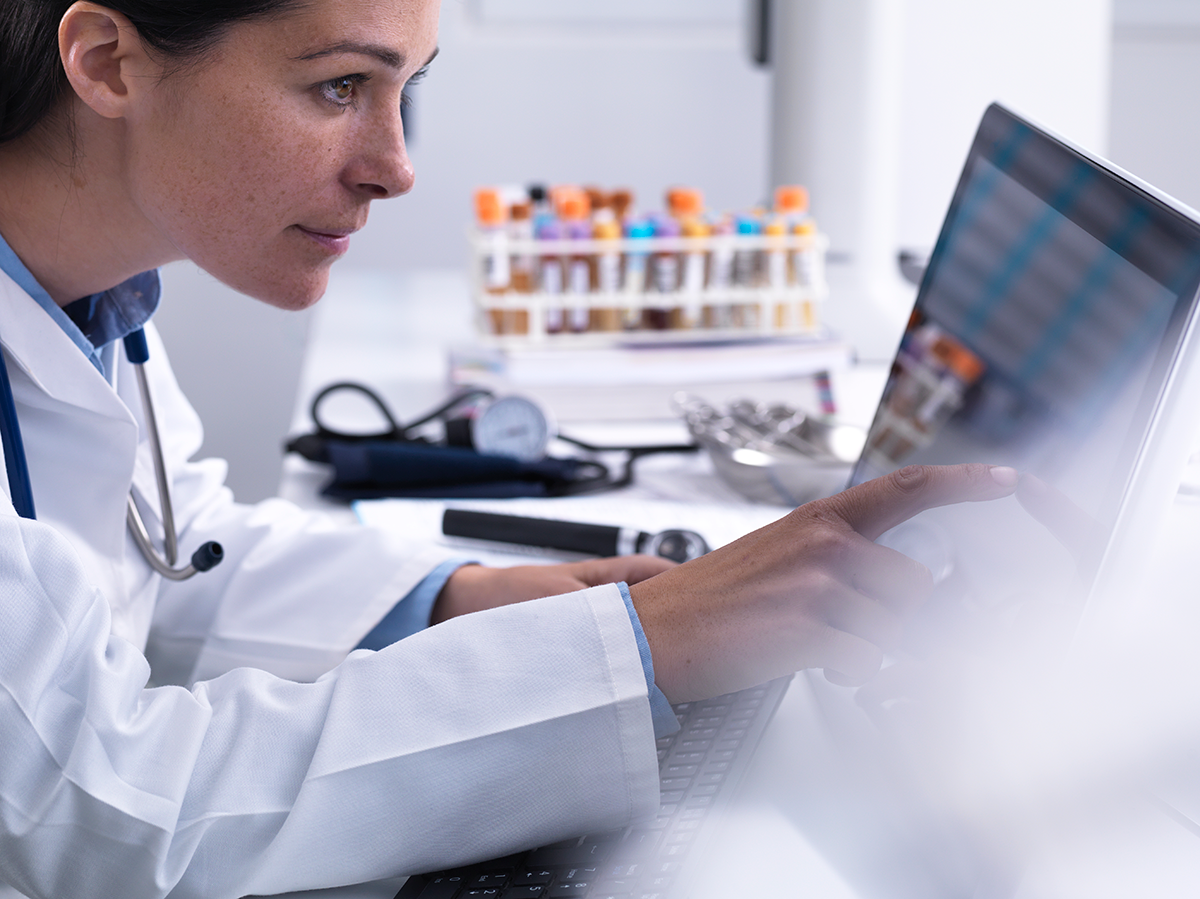 Doctor accessing a patients details using a touch screen computer in a clinic