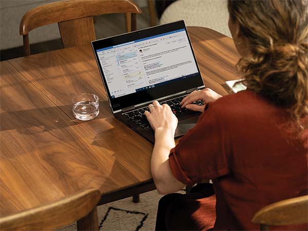 a person sitting at a table with a laptop