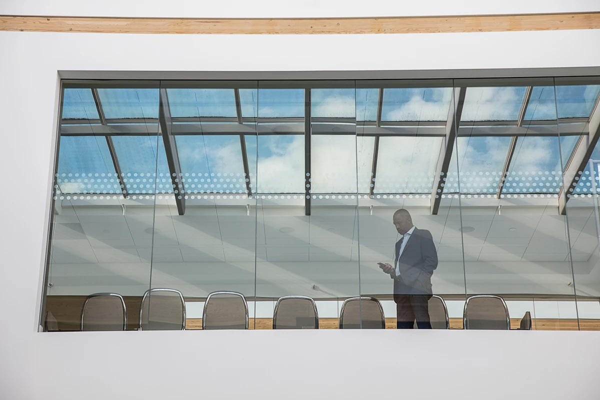 Photo of a man in a meeting room using phone