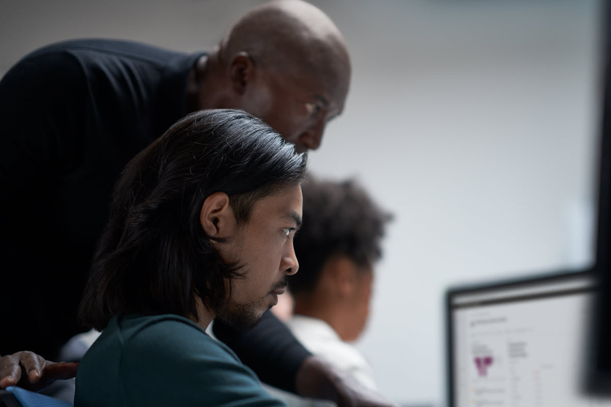 Three security experts looking at a computer