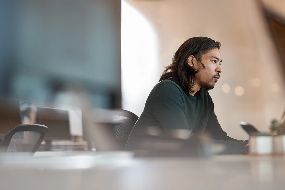 Photo of an enterprise office worker in focused work with a neutral facial expression