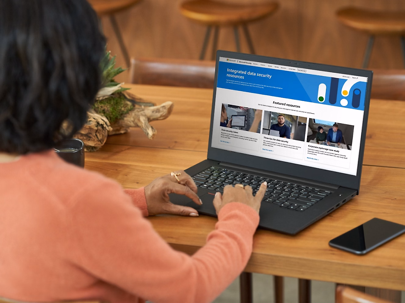 Person typing on laptop with Microsoft integrated data security resources screen.