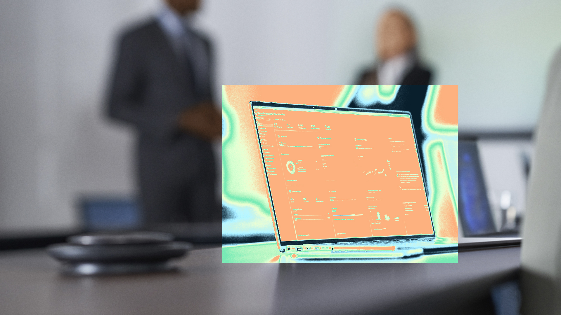 A laptop on a table with two security practitioners standing behind it